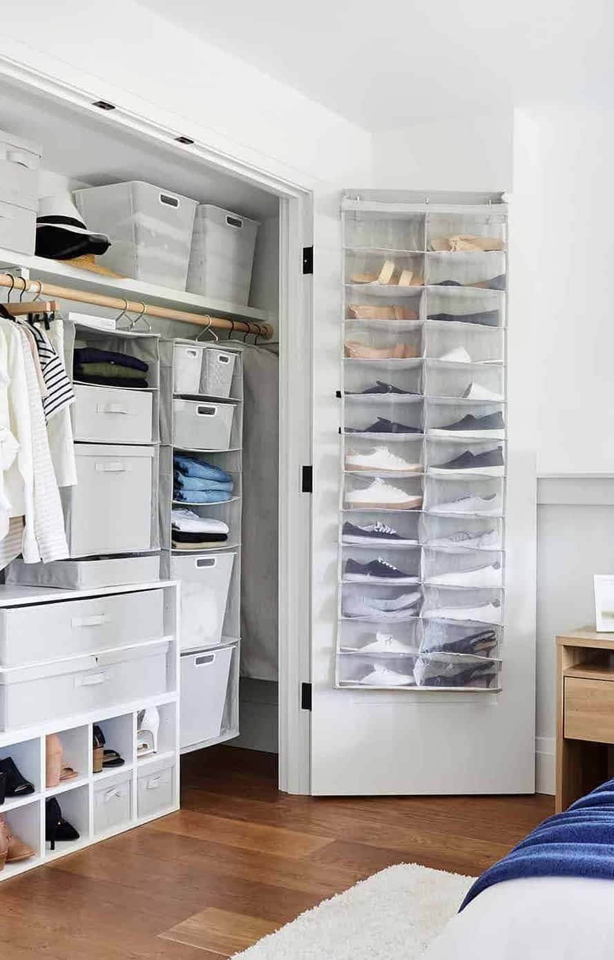 Clóset abierto en tonos neutros con distintas soluciones para ordenar el clóset, desde cajas hasta organizadores colgantes.
