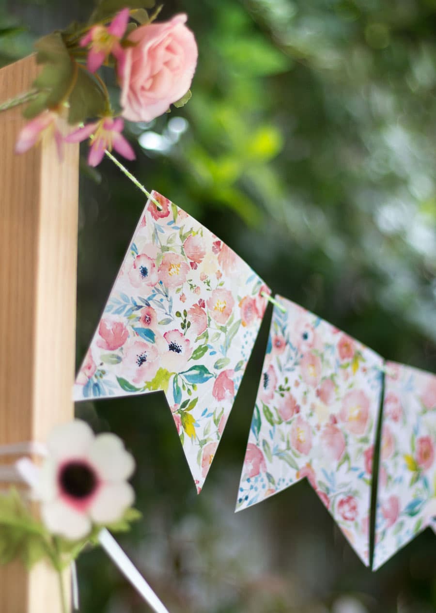 Detalle de una guirnalda decorativa de papel con diseño de flores en colores pastel.