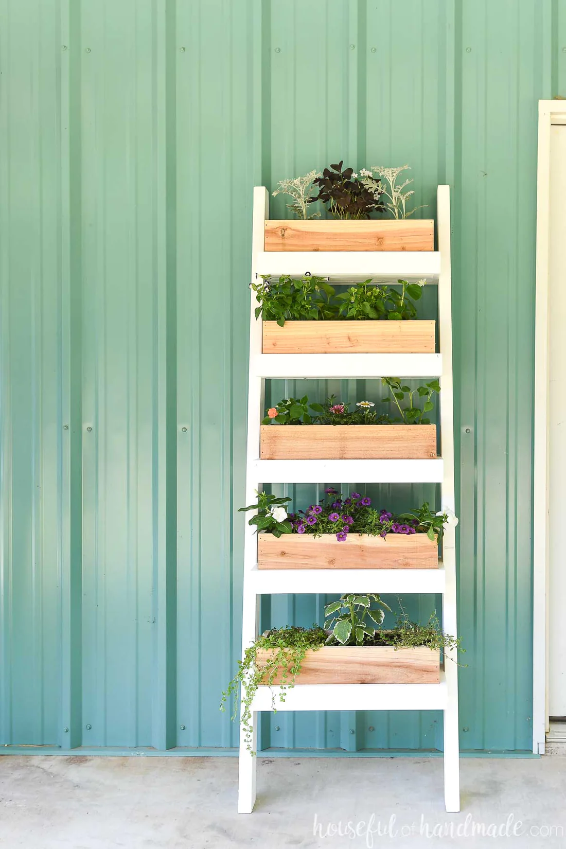Jardín vertical en forma de escalera, con 5 espacios para macetas de madera y plantas.