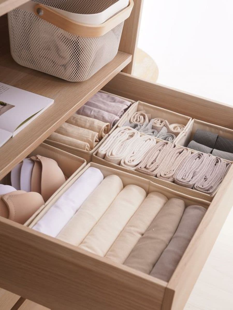 Detalle de un cajón abierto con organizadores para la ropa interior. Son 6 organizadores color beige, de diferentes tamaños con roa en tonos blanco, beige y gris.