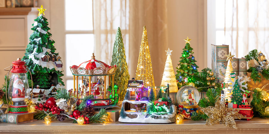 Bodegón decoración navideña: hay un carrusel, miniaturas de árboles de navidad, esferas de nieve, y miniaturas de paisajes navideños.
