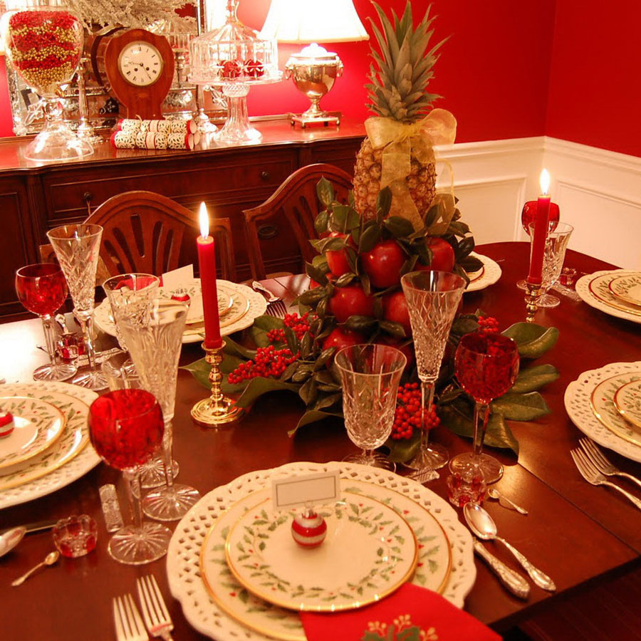 mesa de navidad con centro de mesa hecho de manzanas y una piña