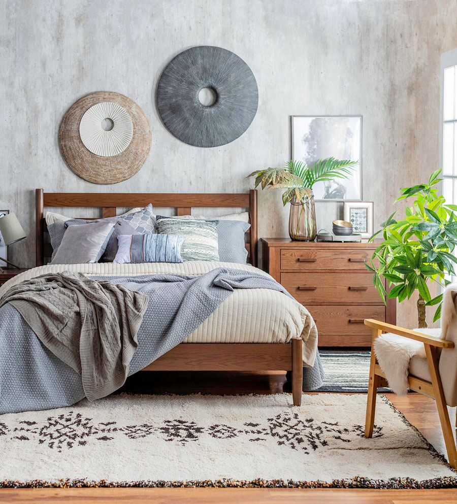 dormitorio de estilo rústico y natural, con cama de estructura de madera, colores neutros, muebles de madera natural, plantas y decoración natural.