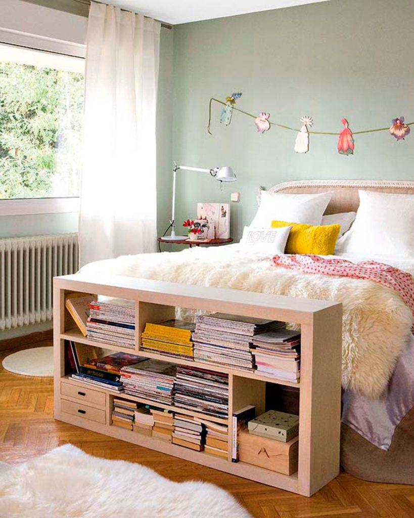 Dormitorio juvenil, con tonos pastel y un modular a los pies de la cama, de madera y con revistas.
