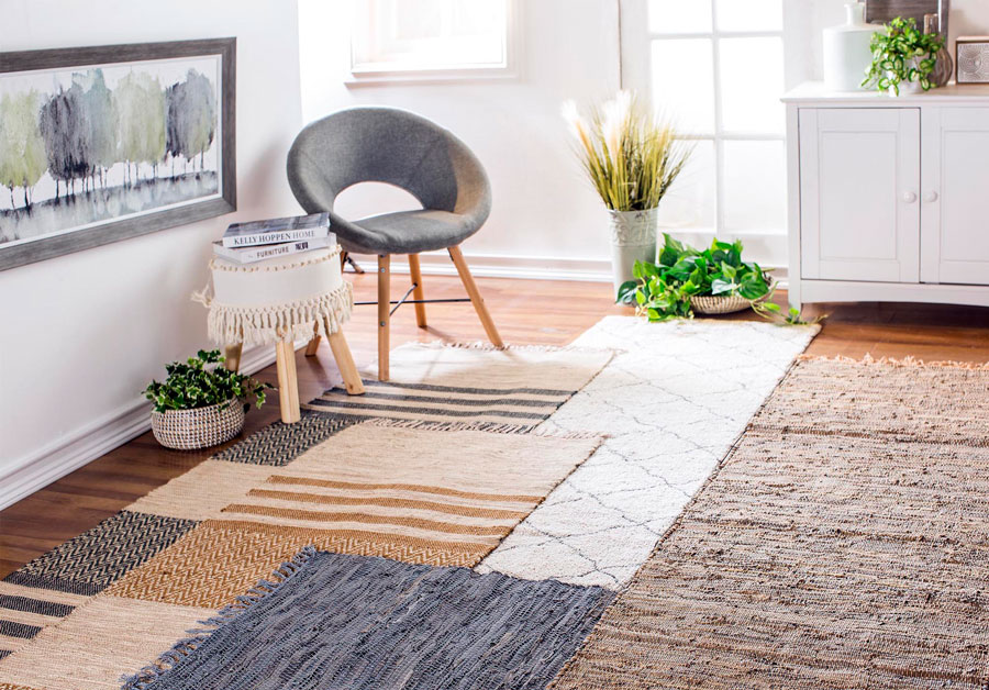 Living con un asiento y muchas alfombras de diferentes diseños y tamaños