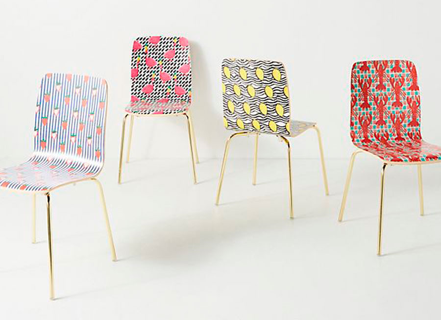 Conjunto de sillas de anthropologie.com de patas delgadas y doradas y base sólida con estampados de flores, frutas, langostas y aves. Un estampado distinto en cada silla.