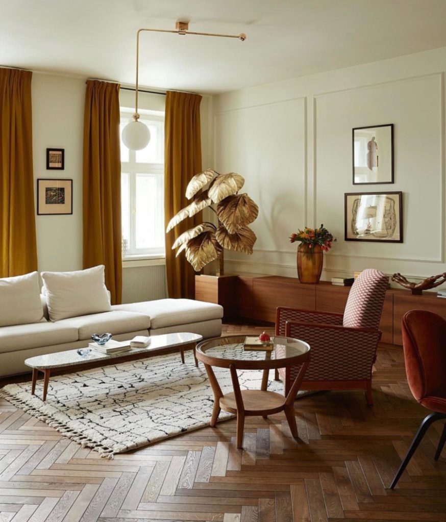 Living en tonos tierra, perfecto para el otoño. Mesa de centro y buffet de madera, sofá , lámpara y alfombra en tonos beige, cortinas color café y cuatro cuadros con marcos negros. Living en tonos tierra, perfecto para el otoño. Mesa de centro y buffet de madera, sofá , lámpara y alfombra en tonos beige, cortinas color café y cuatro cuadros con marcos negros.