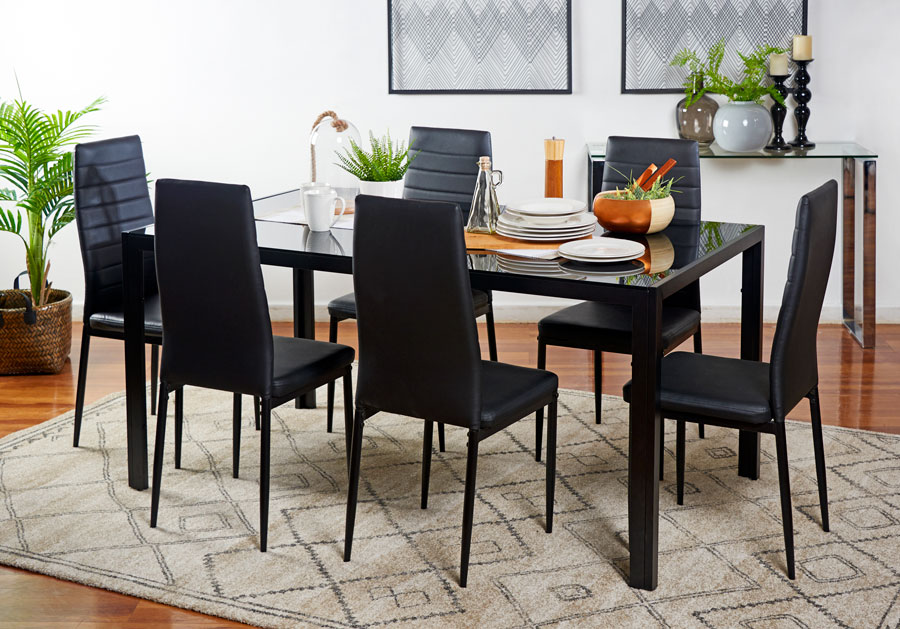 Mesa de comedor rectangular negra con sillas negras sobre alfombra