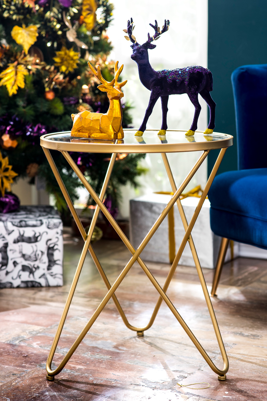 Renos de navidad morado y dorado sobre mesa de patas metálicas doradas