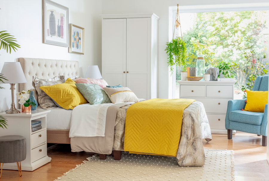 Dormitorio con cama en tonos beige y amarillo 