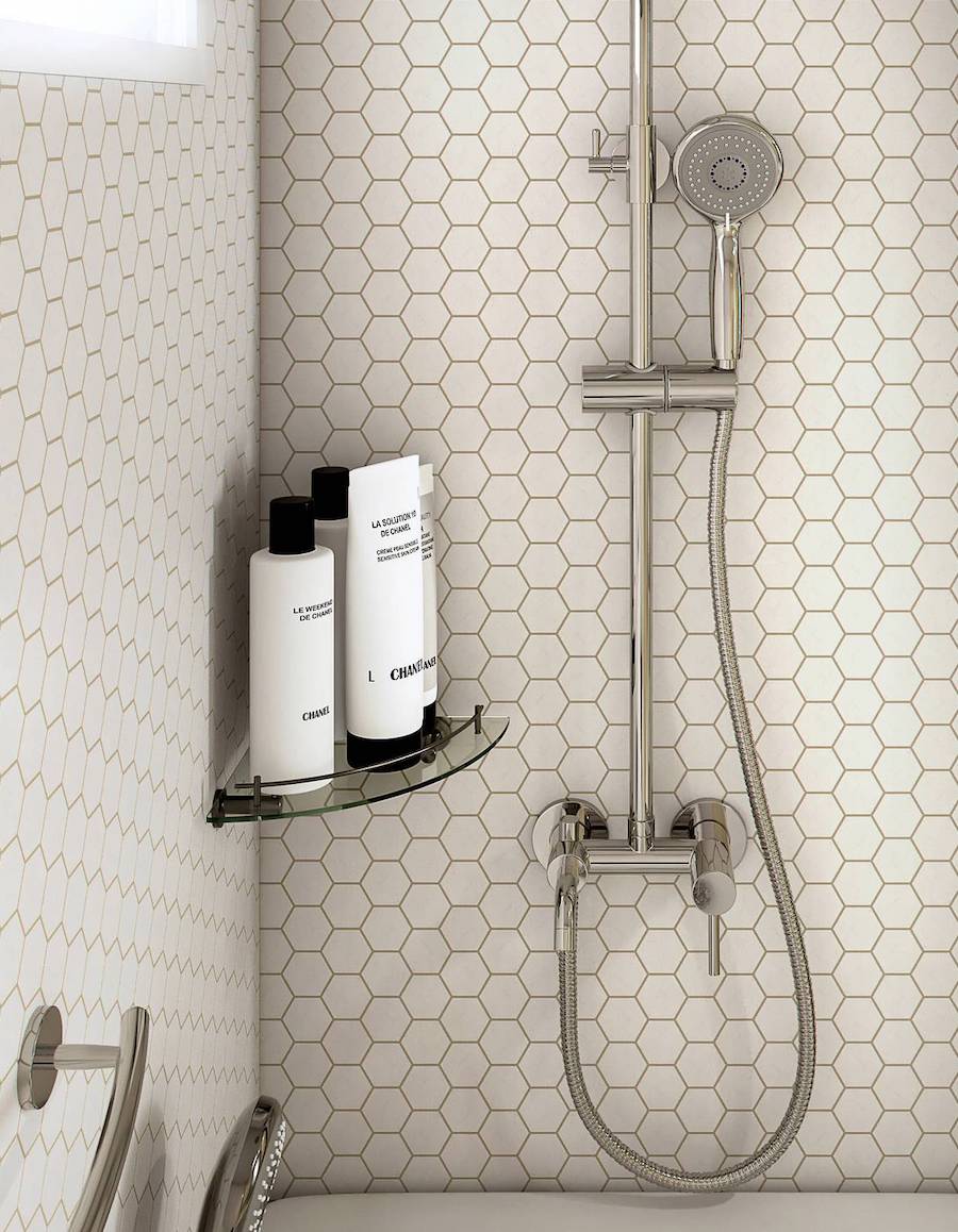 Repisa esquinera de vidrio en una ducha pequeña, contiene productos de higiene personal.