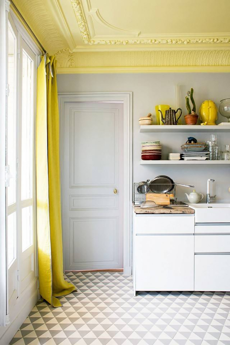 El techo de la cocina pintado color amarillo con muchos adornos de molduras