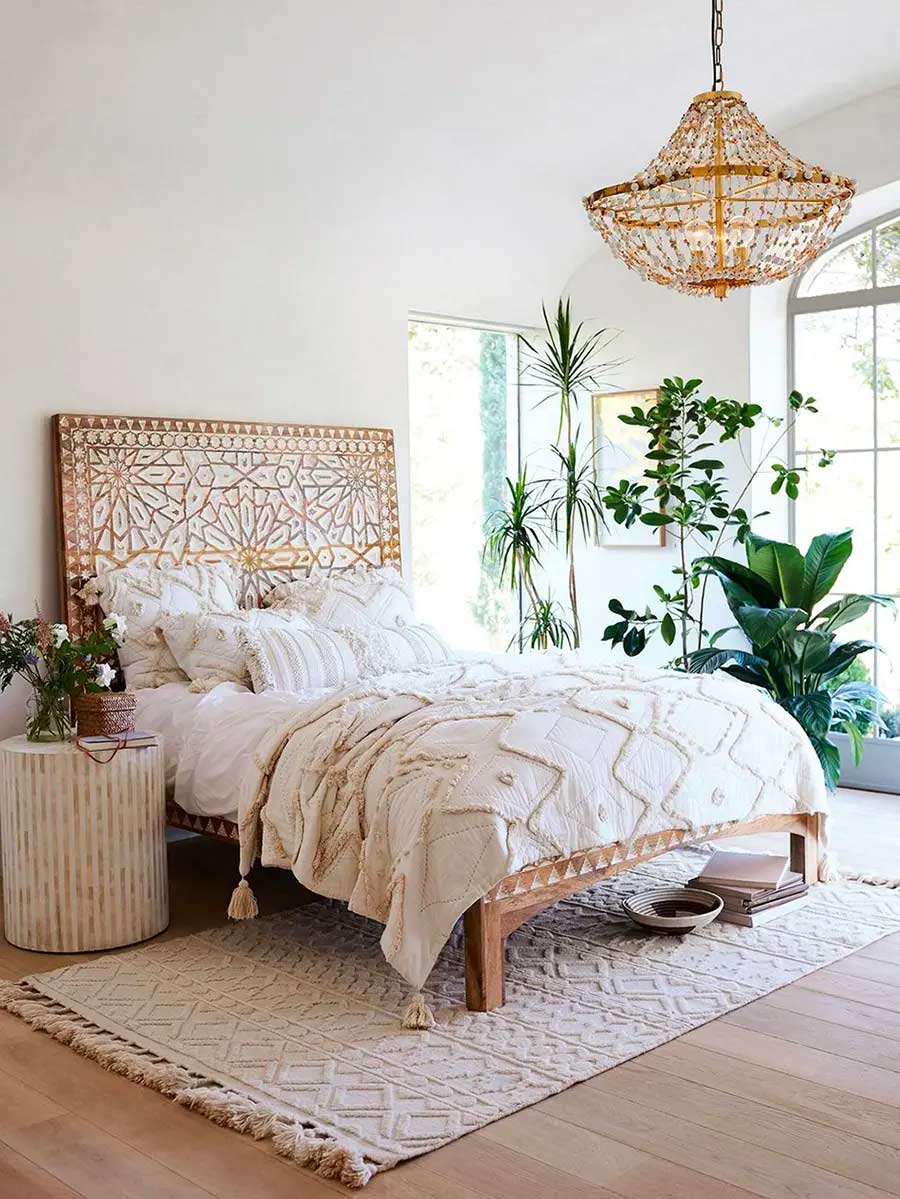 Dormitorio con colores neutros y complementos de fibras naturales. Plantas de adorno dan el acento de color.