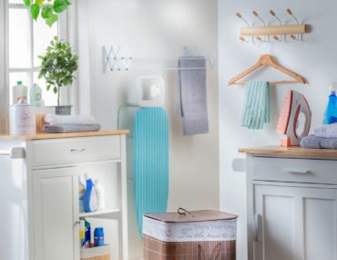 En esta imagen se muestra una logia pequeña, con colgadores y cestos para organizar las toallas y a ropa sucia.