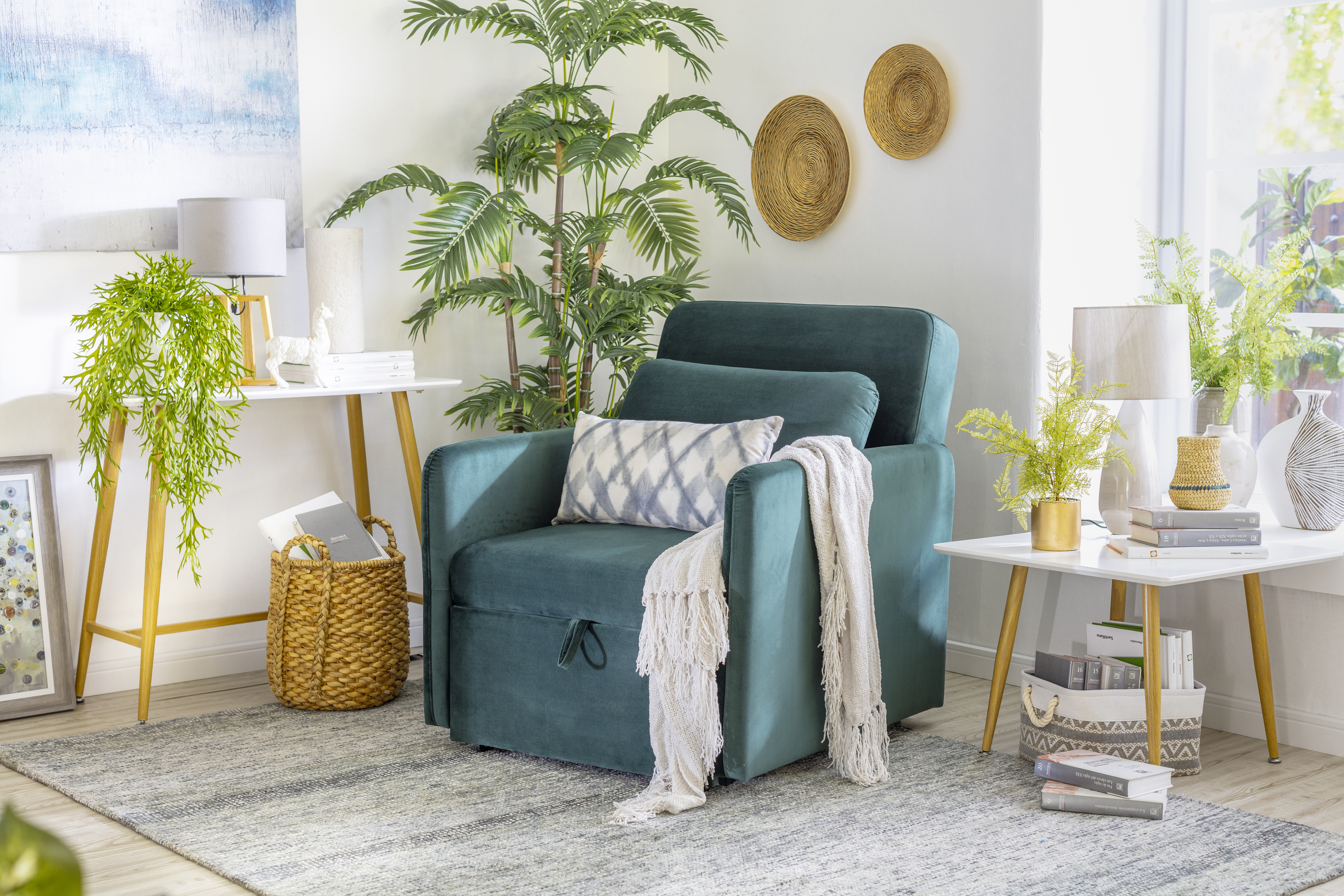 Espacio del hogar con un arrimo blanco con plantas y otras decoraciones, una poltrona velvet verde y una mesa lateral blanca.