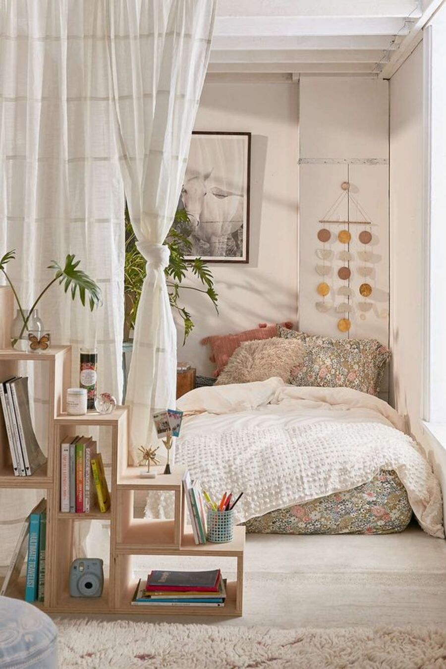 Un hogar estilo estudio con ambientes separados con cortinas de telas en vez de paredes. Por un lado, está el espacio de la cama y, por el otro, una pequeña sala de estar.
