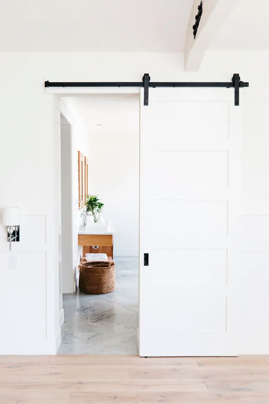 Puerta corredera blanca que separa un espacio del hogar de un pasillo.