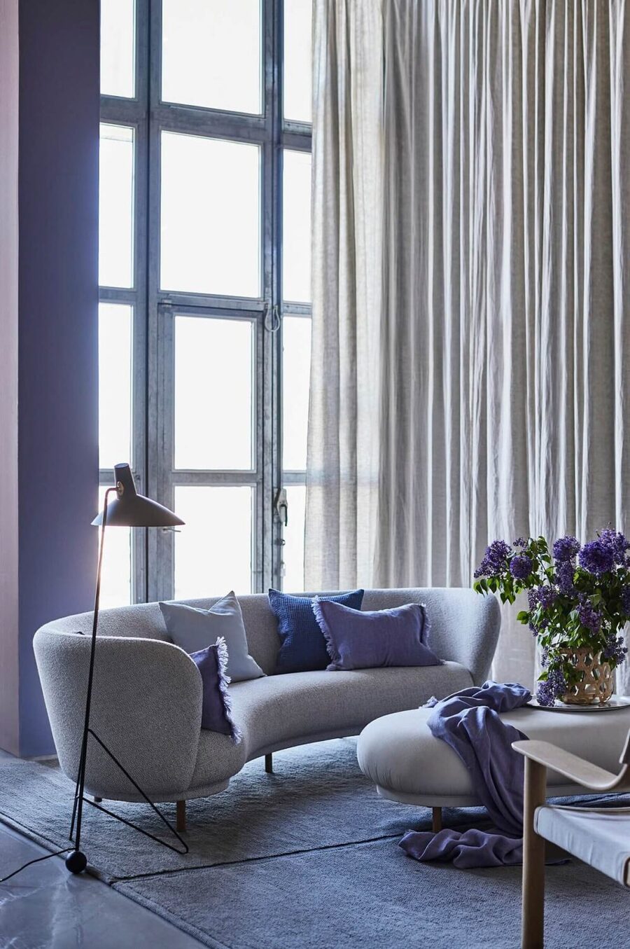El color Pantone del 2022 aplicado en paredes, cojines, mantas y flores en un living.