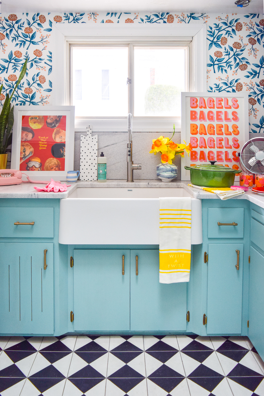 Una cocina muy colorida, con papel mural de flores y hojas en varios tonos.