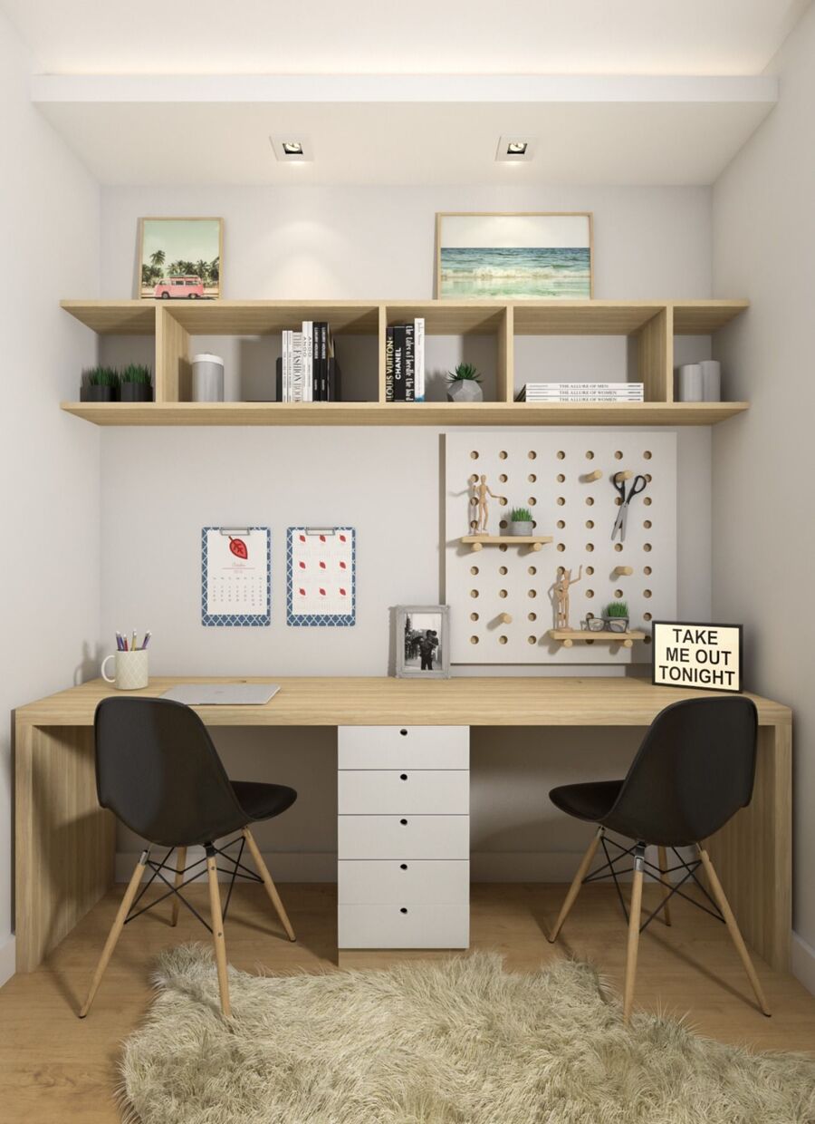 En la fotografía, una cajonera blanca separa dos espacios de trabajo en el escritorio de madera. Sobre el escritorio hay una repisa de madera.
