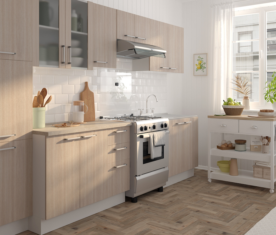 Cocina con muebles de madera clara, una isla de cocina blanca con ruedas pegada a la ventana, azulejos blancos y piso de madera clara. 