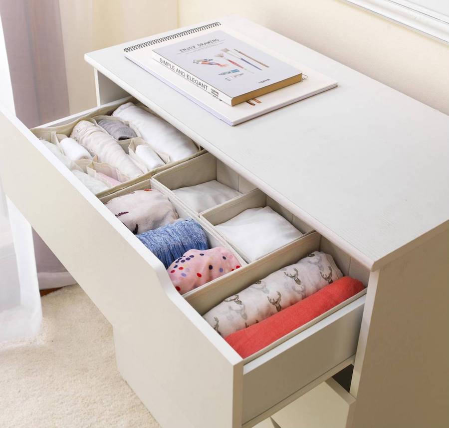 Cómoda con cajón superior abierto, en cuyo interior hay cajas organizadoras de tela que separan las prendas por tipo.