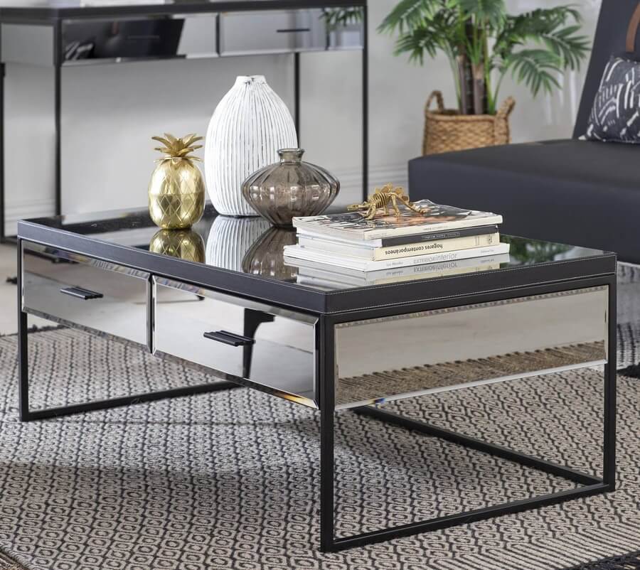 Living estilo glam o clásico, mesa de centro espejada, con dos cajones y patas de metal negras. Alfombra negra con blanco.