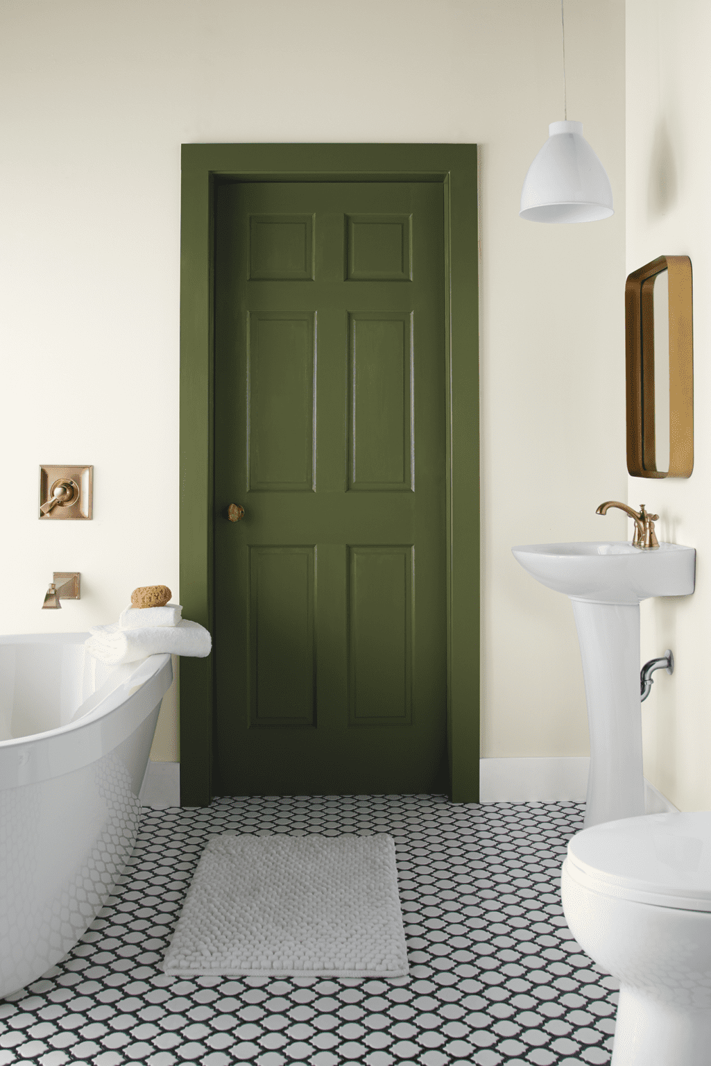 Baño con paredes blancas, suelo con porcelanato hidráulico y una puerta y su marco pintados con color verde olivo.