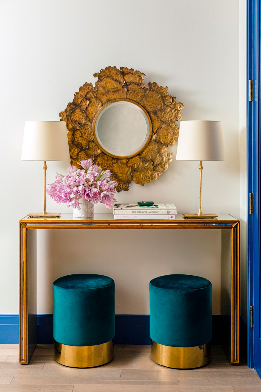 Un rincón glam dorado sobre pared blanca, con pisos cubiertos de terciopelo azul