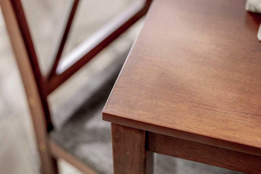 Mesa de madera oscura que, según estudios científicos, ayuda a mantener el calor al interior del hogar y ahorrar energía.