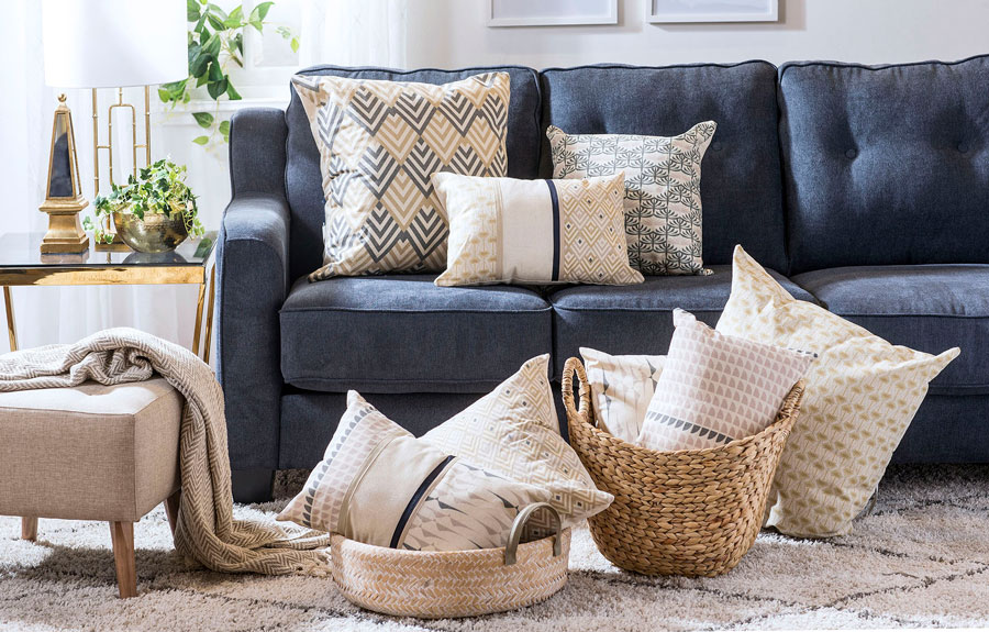 Living con muebles color oscuro y banquetas color crudo comparten espacio con fibras naturales