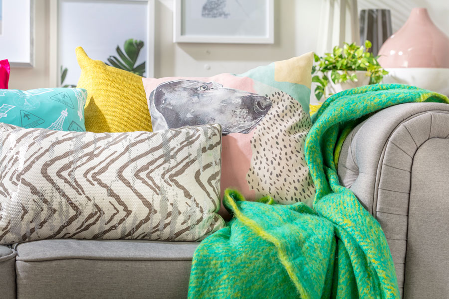 sofá en el living con cojines de distintos colores y texturas