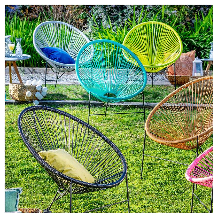 Distintos colores de sillas Acapulco en un jardín
